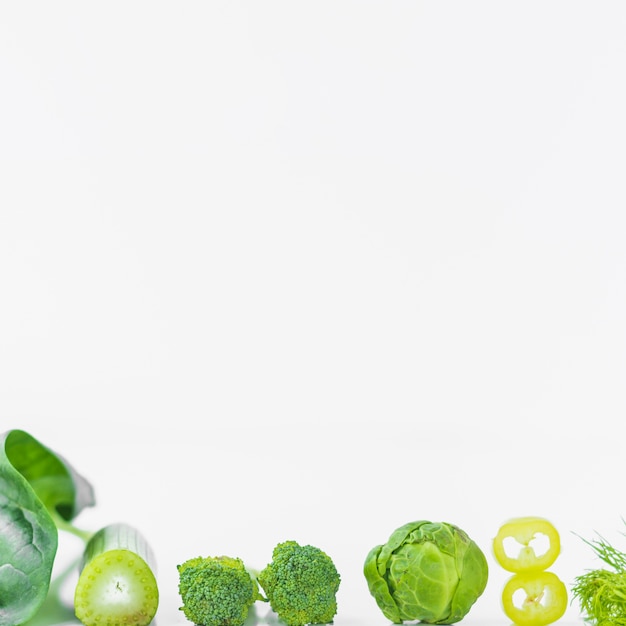 Close-up di verdure fresche verdi su superficie bianca
