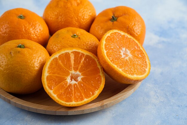 Close up of fresh mandarins on wooden plate