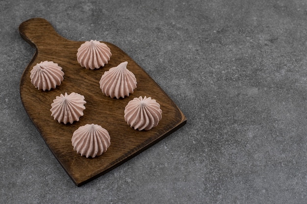 Free photo close up of fresh meringues on wooden cutting board