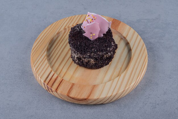 Close up of fresh mini cake on wooden plate 