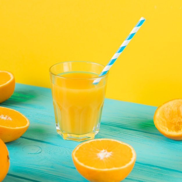 Close up of fresh orange juice glass on blue table