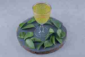 Foto gratuita primo piano di succo di pera fresco con foglie su tavola di legno