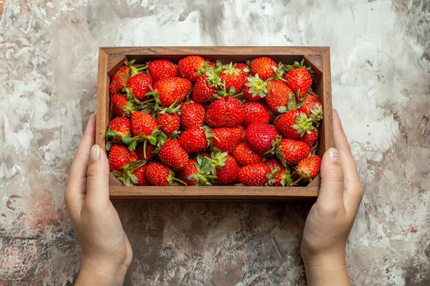 Close up on fresh strawberries in a small brown wooden box