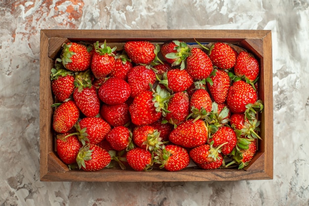 Close up on fresh strawberries in a small brown wooden box