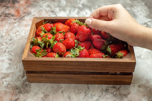Close up on fresh strawberries in a small brown wooden box