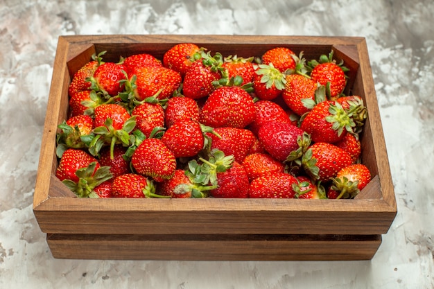Close up on fresh strawberries in a small brown wooden box