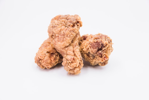 Close-up of a fried chicken drumstick on white backdrop