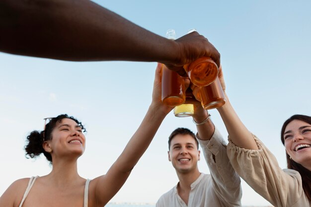 Close up friends clinking bottles