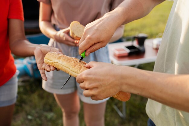 Close up friends cutting bread