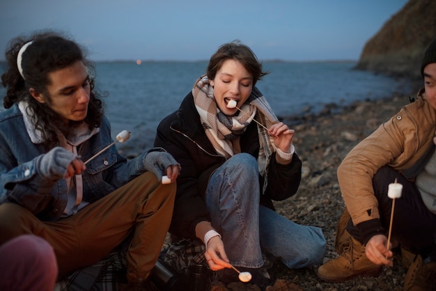 Free photo close up friends eating marshmallows