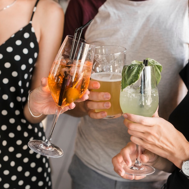 Close-up of friends hand holding glass of drinks