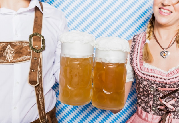 Close-up friends holding beer mugs