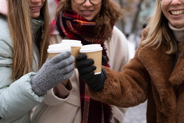 コーヒーカップを持っているクローズアップの友人