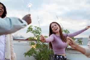 Free photo close up friends holding fireworks