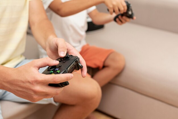 Close-up friends holding game controllers