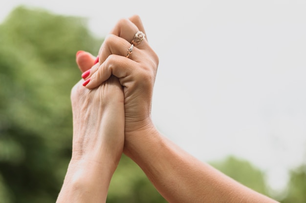 Close-up friends holding hands