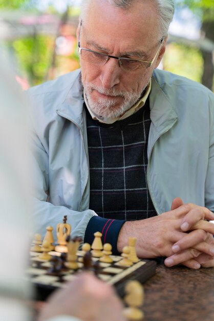 Close up friends playing chess together