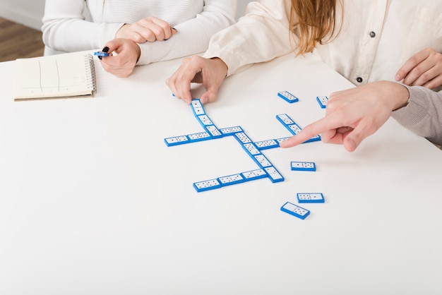 Foto gratuita amici di close-up che giocano una partita di domino