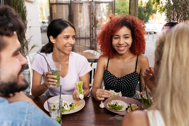 Foto gratuita chiudi gli amici con bevande e tacos