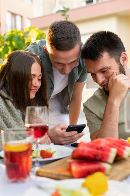 Close up friends with food and smartphone