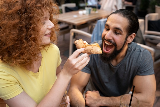 Free photo close up friends with pizza slice