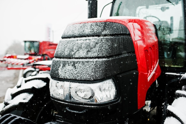 Close up in front of the new red tractor at snowy weather