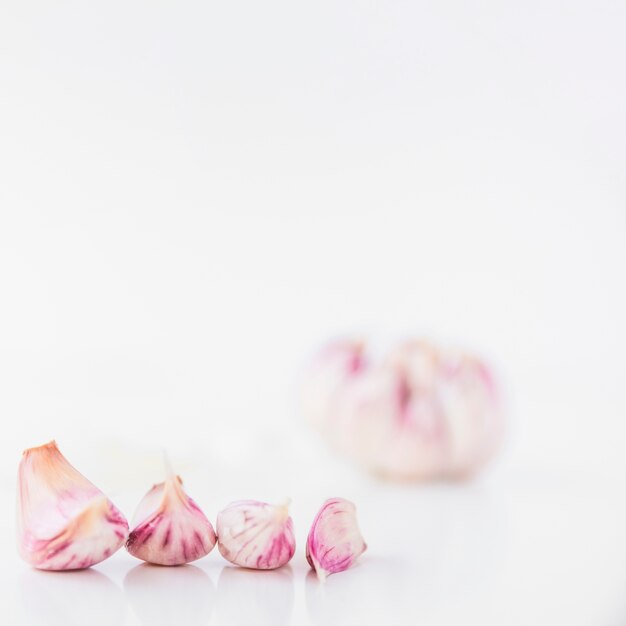 Close-up of garlic cloves on white backdrop