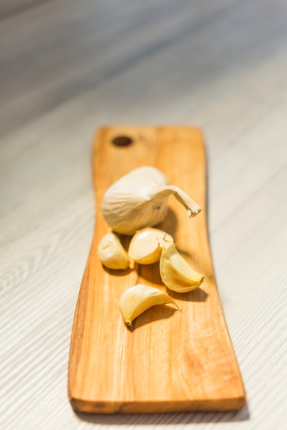 Close-up of garlic cloves on wooden chopping board