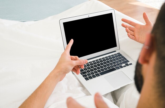 노트북 화면을 향해 자신의 손가락을 가리키는 게이 커플의 근접