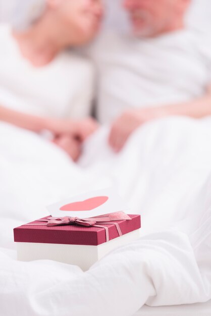 Close-up of gift box with greeting card on white blanket