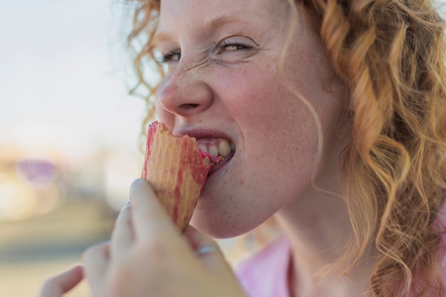 Close-up girl biting ice cream cone