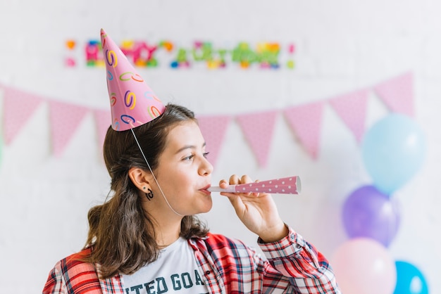 Free photo close-up of a girl blowing party horn