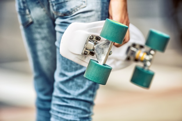 Close up of girl or boy holding his penny skateboard.