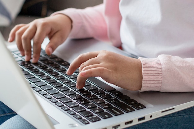 Close-up girl browsing laptop at home