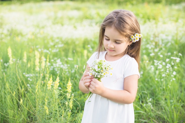 Foto gratuita primo piano di una ragazza che raccoglie fiori bianchi in mano
