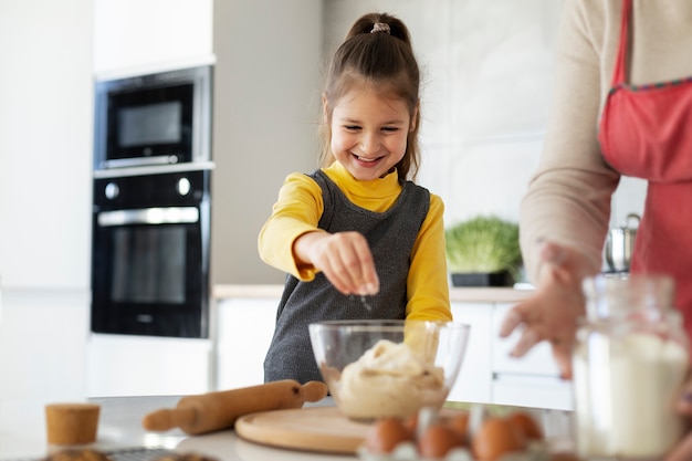 Close up on girl cooking with her grandmother