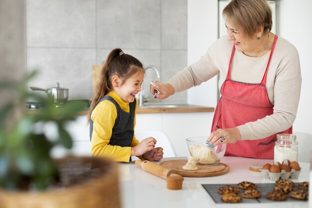 Close up on girl cooking with her grandmother