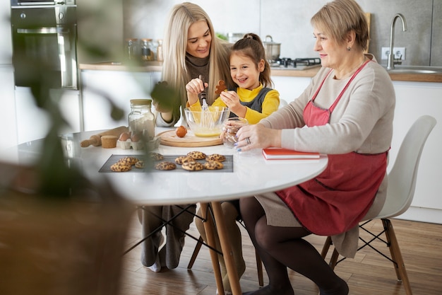 Primo piano sulla ragazza che cucina con sua madre e sua nonna