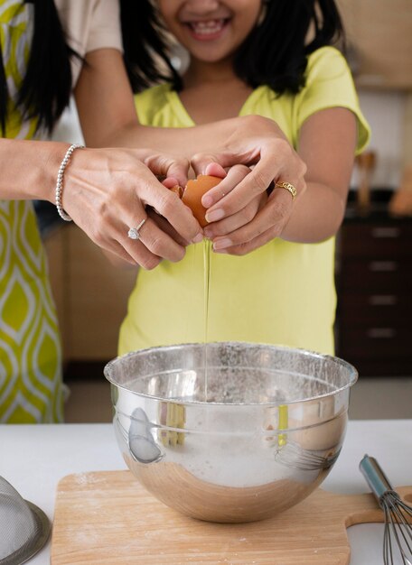 Close up girl cracking egg