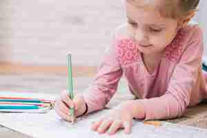 Free photo close-up of a girl drawing in book with colored pencil