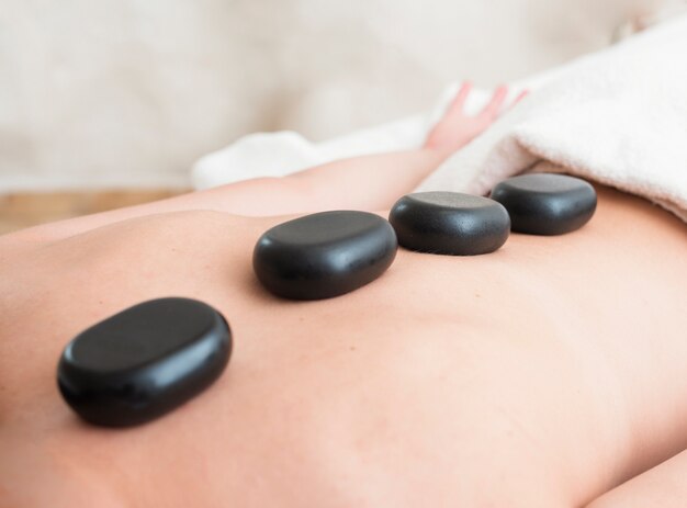 Close-up girl getting a spa treatment with stones