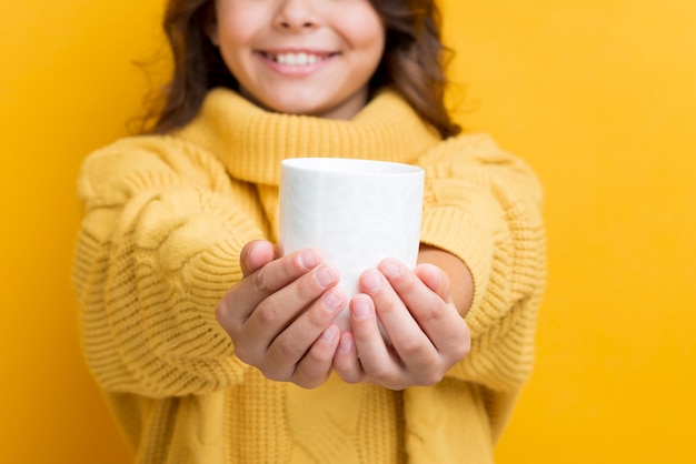 Крупным планом девушка держит чашку с горячим чаем