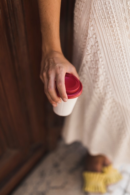 Крупный план девочка, держащая одноразовые кофейные чашки в руке