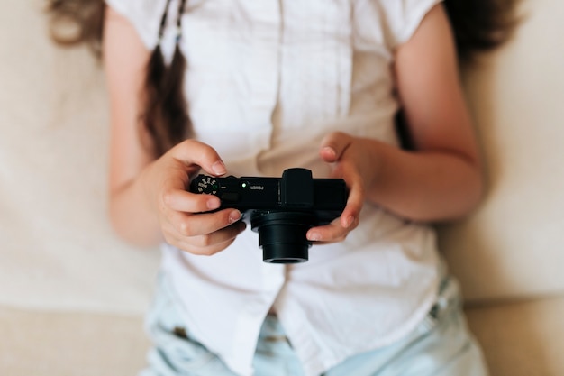 Foto gratuita ragazza del primo piano che tiene una macchina fotografica