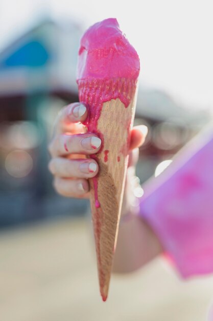 Макро девушка держит розовое мороженое