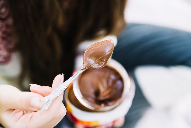 Close-up of girl holding spoon of melted chocolate