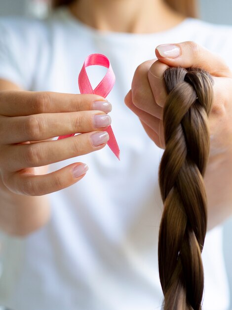 Free Photo close-up girl holding up braid and ribbon