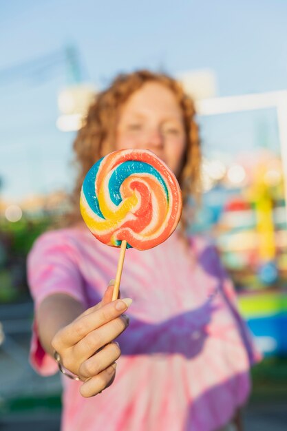 Close-up girl holding up lollipop