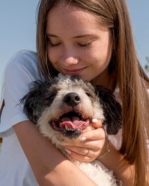 かわいい犬を抱き締めるクローズアップの女の子