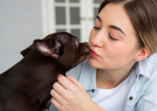 Close-up girl kissing cute dog